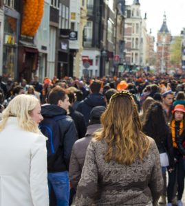 Crowd of people walking down a busy street